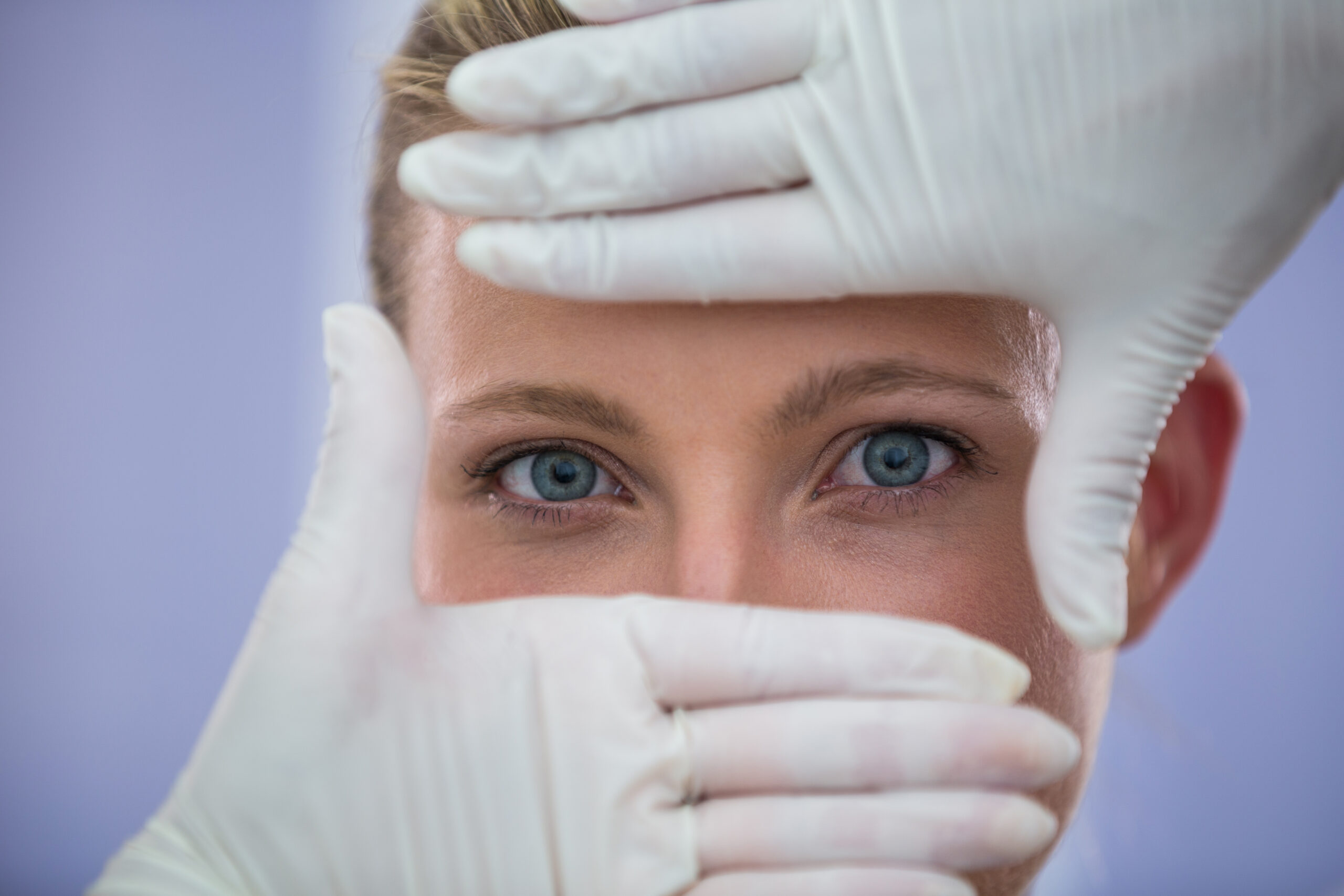 Doctor examining female patients face from cosmetic treatment